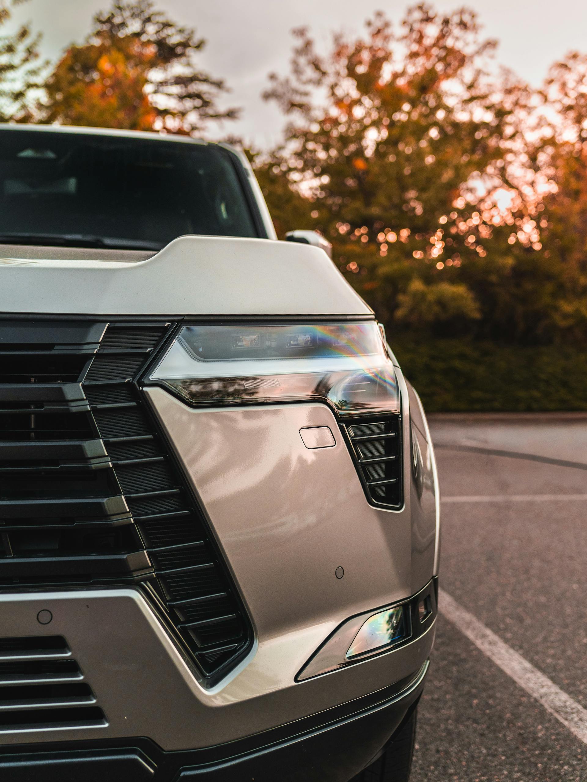 Stunning close-up of a luxury SUV at sunset in Ashburn, Virginia, highlighting sleek design and elegance.